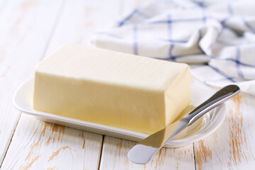 butter and knife on a white wooden table, selective focus.