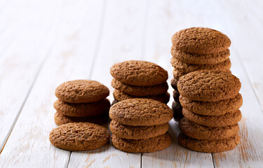 Stack of round oatmeal cookies on a white table, selective focus.