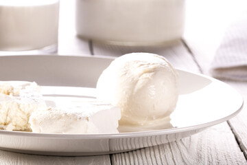 Glass of milk, cottage cheese and mozzarella on a white plate