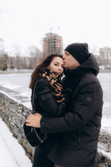 A winter walk of a couple in love in the park. A man tenderly kisses a girl.