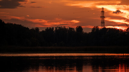 Fototapeta premium Summer sunset over a lake with grass in the foreground.