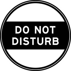 Black color round seal sticker in word do not disturb on white background
