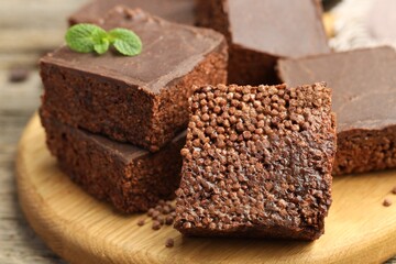 Delicious chocolate puffed rice bars and mint on table, closeup