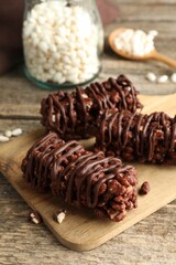 Delicious chocolate puffed rice bars on wooden table, closeup