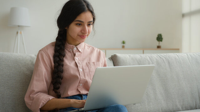 Female Arabian woman girl typing laptop at home working in quarantine Indian businesswoman student studying online e-learning business internet chatting use computer app make order website freelance