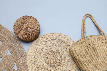 Set of sraw wicker and bamboo items on gray background with copy space. Basket,mat napkin, bag,jute rug. Zero waste concept.