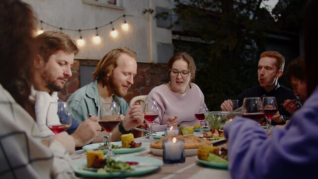 Friends enjoying dinner and wine together on an outdoor patio