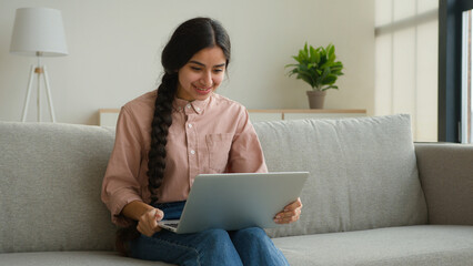Smiling Arabian woman talk to friend on laptop online video conference application pleasant...