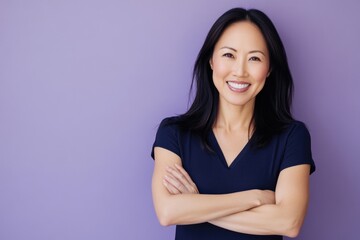 Fototapeta premium A woman stands confidently in front of a purple wall, looking directly at the camera