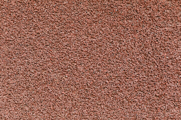 A detailed close-up texture of small dark brown gravel stones, evenly spread creating a rugged and earthy feel, ideal for backgrounds or construction themes.
