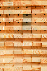 A close-up view of neatly stacked wooden blocks, showcasing their warm hues and distinct grain patterns. The texture and arrangement highlight the natural beauty of woodwork.