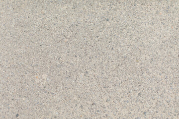 Detailed texture of light gray concrete surface with small gravel and stone aggregates scattered throughout.