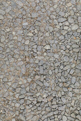 A detailed close-up texture of small gray gravel stones, evenly spread across the frame, creating a rugged and earthy surface, ideal for backgrounds or construction themes.
