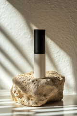 Decorative object displayed on a textured stone with soft shadows highlighting its form in a bright interior space