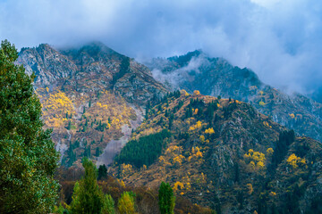Fototapeta premium Foggy mountain peaks near lake Issyk, Kazakhstan during an autumn morning