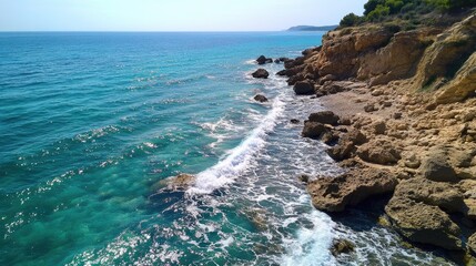 Obraz premium Turquoise Mediterranean coastline with gentle summer waves perfect for landscape backgrounds or travel related design projects