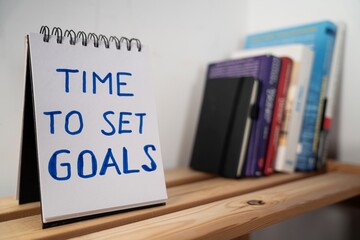 otwarty notes na półce z kartką na której zapisany jest tekst: Time to set goals © siwyk