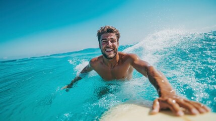 Surfer's Joy: A joyful young man rides a wave, his face radiant with happiness. The vibrant turquoise water and clear blue sky create a stunning backdrop for this exhilarating moment.