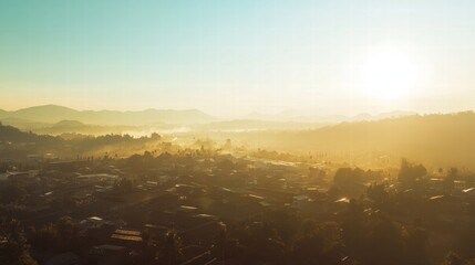 Naklejka premium Golden Hour Over the Valley: A breathtaking aerial panorama captures the golden glow of sunrise over a picturesque valley, showcasing the tranquil beauty of nature in the early morning light. 