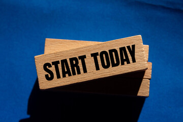 Start today message written on wooden blocks with blue background. Conceptual start today symbol....