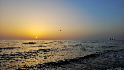 Sunset over the Mediterranean Sea, with golden light reflecting on gentle waves