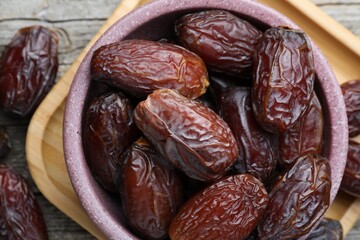 Many tasty dried dates in bowl on table, top view