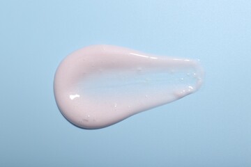 Cream sample on light blue background, top view