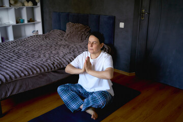a senior woman performs somatic exercises, yoga at home