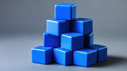 Obraz premium Stack of blue cubes on gray background.