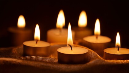 a group of candles burning brightly on dark background