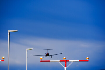 Street light and beacon with propeller airplane landing at Swiss Airport Zürich Kloten on a winter...