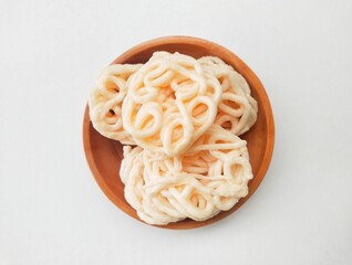 Palembang fish crackers in a wooden plate on a white background.