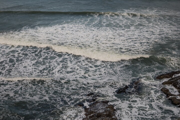 Obraz premium Ocean waves crashing over rocky shoreline