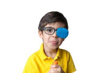 Boy in glasses with eye patch with a carrot. Occluder, lazyeye, amblyopia, strabismus. Vision testing concept. Reviewing eyesight