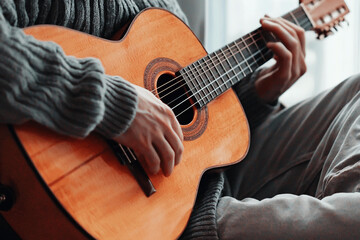 Fototapeta premium Musician enjoys playing guitar in cozy space