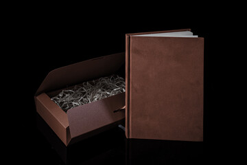 Best gift for men. Man gift concept. Red notebook with red gift box on black background. Copy space. Valentine's day, wedding, birthday and special occasion gift concept. Copy space for text.