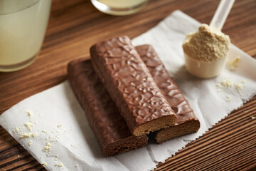 Healthy vegetarian protein chocolate bars with a scoop of whey protein powder