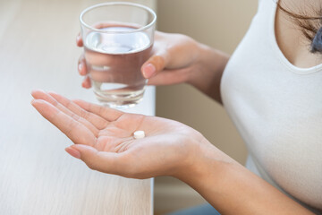 Sick asian young woman, girl holding tablet pill on hand, painkiller medicine from fever, stomach...