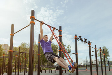 Training muscle-up technique with resistance bands on outdoor pull-up bar