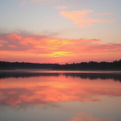 A tranquil lake reflecting a sunset with vibrant hues