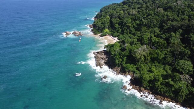 Aerial view of Mono Manso Beach, a secluded tropical paradise near Chuspa, Venezuela &ndash; Lush green forest, rocky shoreline, golden sand, and crystal-clear turquoise water