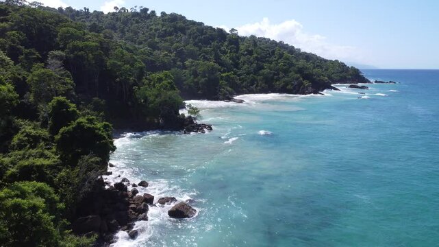 Aerial view of Mono Manso Beach, a secluded tropical paradise near Chuspa, Venezuela &ndash; Lush green forest, rocky shoreline, golden sand, and crystal-clear turquoise water