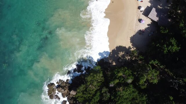 Aerial view of Mono Manso Beach, a secluded tropical paradise near Chuspa, Venezuela &ndash; Lush green forest, rocky shoreline, golden sand, and crystal-clear turquoise water