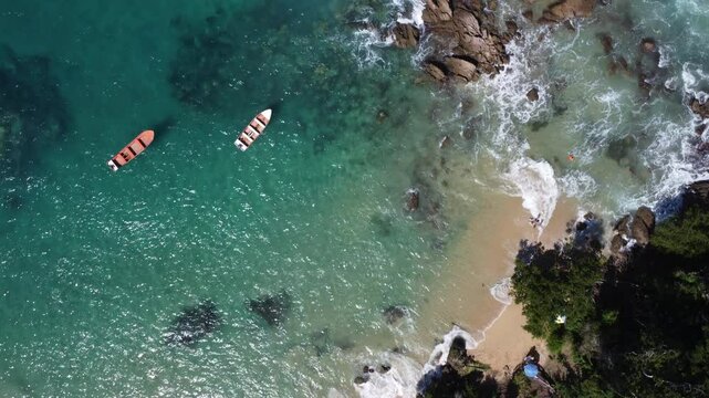 Aerial view of Mono Manso Beach, a secluded tropical paradise near Chuspa, Venezuela &ndash; Lush green forest, rocky shoreline, golden sand, and crystal-clear turquoise water