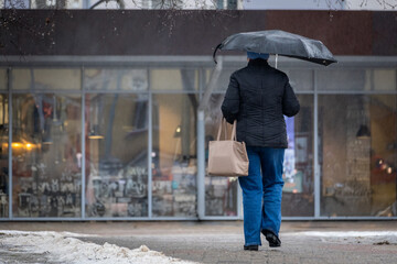 Urban Winter Stroll with Umbrella Near Burger Shop. City Life: Woman Walking in the Rainy Winter.