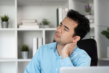Young Businessman Experiencing Discomfort at Work in Modern Office Setting