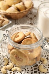 Tasty cashew cookies in jar on table, closeup