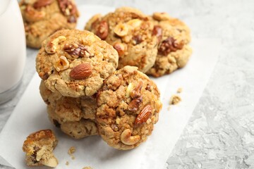 Tasty cookies with nuts on grey table, closeup. Space for text