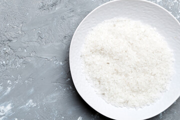 A wooden bowl of salt crystals on a wooden background. Salt in rustic bowls, top view with copy space