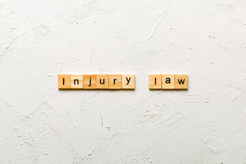 INJURY law word written on wood block. INJURY law text on table, concept